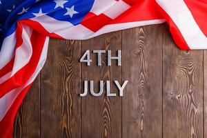 les mots 4 juillet et drapeau usa froissé sur fond de surface en bois texturé plat photo