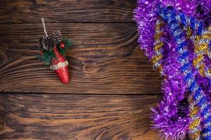 guirlandes de noël et jouet rouge sur le fond d'une vieille table en bois marron. photo