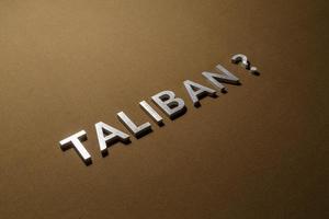 la question taliban posée avec des lettres en métal argenté sur une toile rugueuse beige kaki photo