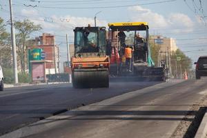 tula, russie 16 mai 2021 processus d'asphaltage, finisseur d'asphalte et rouleau compresseur pendant les travaux de construction de routes, en été photo