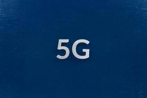 le mot 5g posé avec des lettres en aluminium sur fond bleu foncé photo