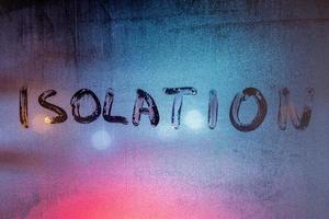 le mot isolement écrit à la main sur une vitre humide la nuit - photo plein cadre en gros plan avec mise au point sélective