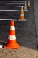 cônes de route orange sur une aire de conduite en asphalte avec des lignes blanches photo