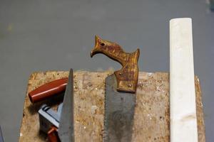 rabot, scie et bloc de bois sur un tabouret photo