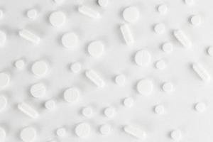 fond plat de pilules, comprimés étalés sur un blanc - vue de dessus photo