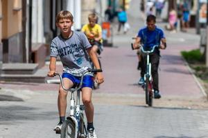 tula, russie, 1er juin 2014, adolescents faisant du vélo sur le trottoir dans la ville d'été à la journée ensoleillée avec mise au point sélective. photo