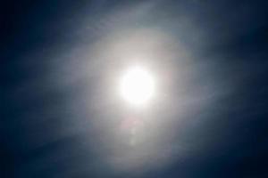 particules de poussière volant dans l'air sur fond de ciel bleu avec soleil et nuage de plumes au printemps photo