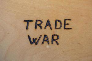 les mots guerre commerciale écrits à la main sur une surface plate en contreplaqué nu avec poêle à bois photo