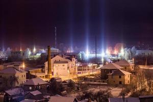 paysage urbain d'hiver de nuit avec des piliers de lumière phénomène atmosphérique photo