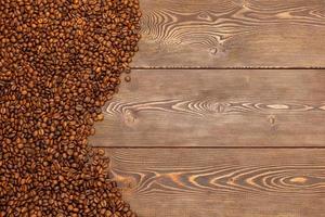 grains de café torréfiés posés sur une surface de table en bois marron photo