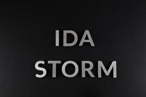 mots ida storm posés avec des lettres en métal argenté sur une surface mate noire sèche photo
