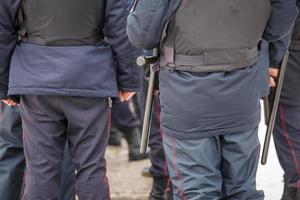 Officier de police russe avec bâton de tonfa en caoutchouc noir suspendu à sa ceinture photo