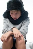 portrait d'un gars bouleversé en bonnet et écharpe d'hiver, hiver froid et temps de crise. photo