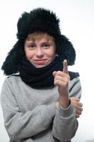 chapeau d'hiver avec oreillettes et écharpe, portrait d'un garçon en vêtements d'hiver. photo