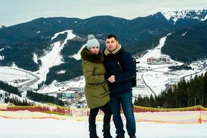 deux personnes sur le fond d'une station de ski, de montagnes pittoresques et de vacances d'hiver. photo