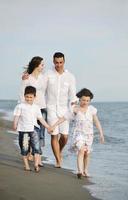 jeune famille heureuse s'amuser sur la plage photo