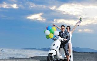 couple juste marié sur la plage ride scooter blanc photo