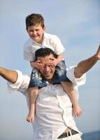 heureux père et fils s'amusent et profitent du temps sur la plage photo