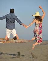 couple sur la plage avec sac de voyage photo