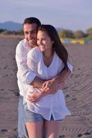 jeune couple sur la plage s'amuser photo