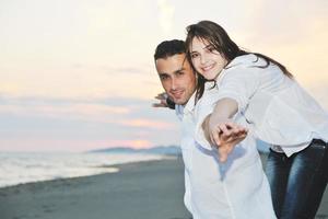 heureux jeune couple s'amuser sur la plage photo