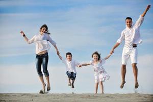 famille sur la plage montrant le signe de la maison photo