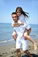 heureux jeune couple s'amuser sur la plage photo