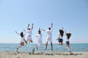 groupe de personnes heureuses s'amuser et courir sur la plage photo