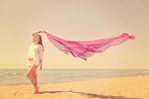 belle jeune femme sur la plage avec foulard photo
