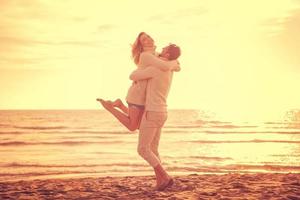 jeune couple aimant sur une plage à la journée ensoleillée d'automne photo