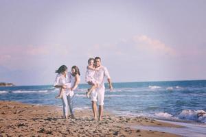 jeune famille heureuse s'amuser sur la plage photo