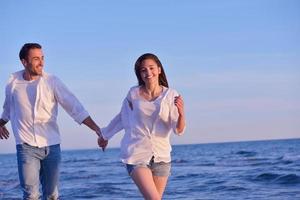 jeune couple sur la plage s'amuser photo