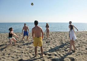 un groupe de jeunes s'amuse et joue au beach-volley photo