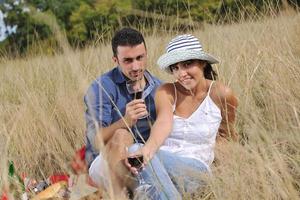 couple heureux profitant d'un pique-nique à la campagne dans l'herbe haute photo