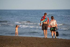 jeune famille se détendre sur la plage photo