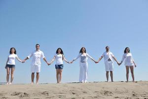 groupe de personnes heureuses s'amuser et courir sur la plage photo