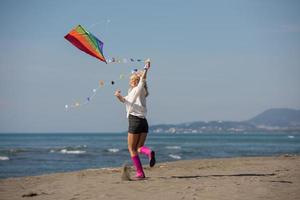 jeune femme avec cerf-volant à la plage le jour de l'automne photo