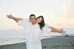 heureux jeune couple s'amuser sur la plage photo