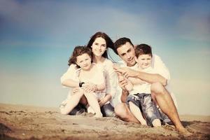 jeune famille heureuse s'amuser sur la plage photo