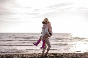 jeune couple aimant sur une plage à la journée ensoleillée d'automne photo