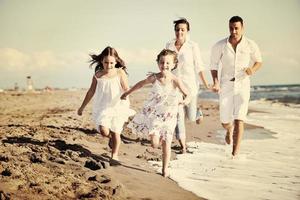 jeune famille heureuse s'amuser sur la plage photo