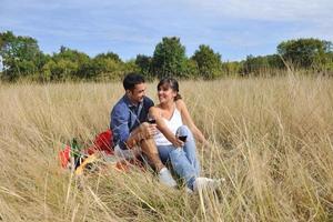 couple heureux profitant d'un pique-nique à la campagne dans l'herbe haute photo