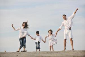 jeune famille heureuse s'amuser sur la plage photo