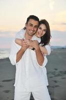 heureux jeune couple s'amuser sur la plage photo