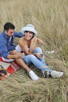 couple heureux profitant d'un pique-nique à la campagne dans l'herbe haute photo