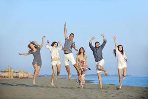 groupe de jeunes heureux s'amuser sur la plage photo