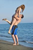 un jeune couple heureux passe un moment romantique sur la plage photo