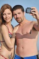 heureux jeune couple amoureux prenant des photos sur la plage