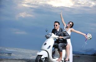 couple juste marié sur la plage ride scooter blanc photo