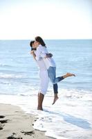 heureux jeune couple s'amuser sur la belle plage photo